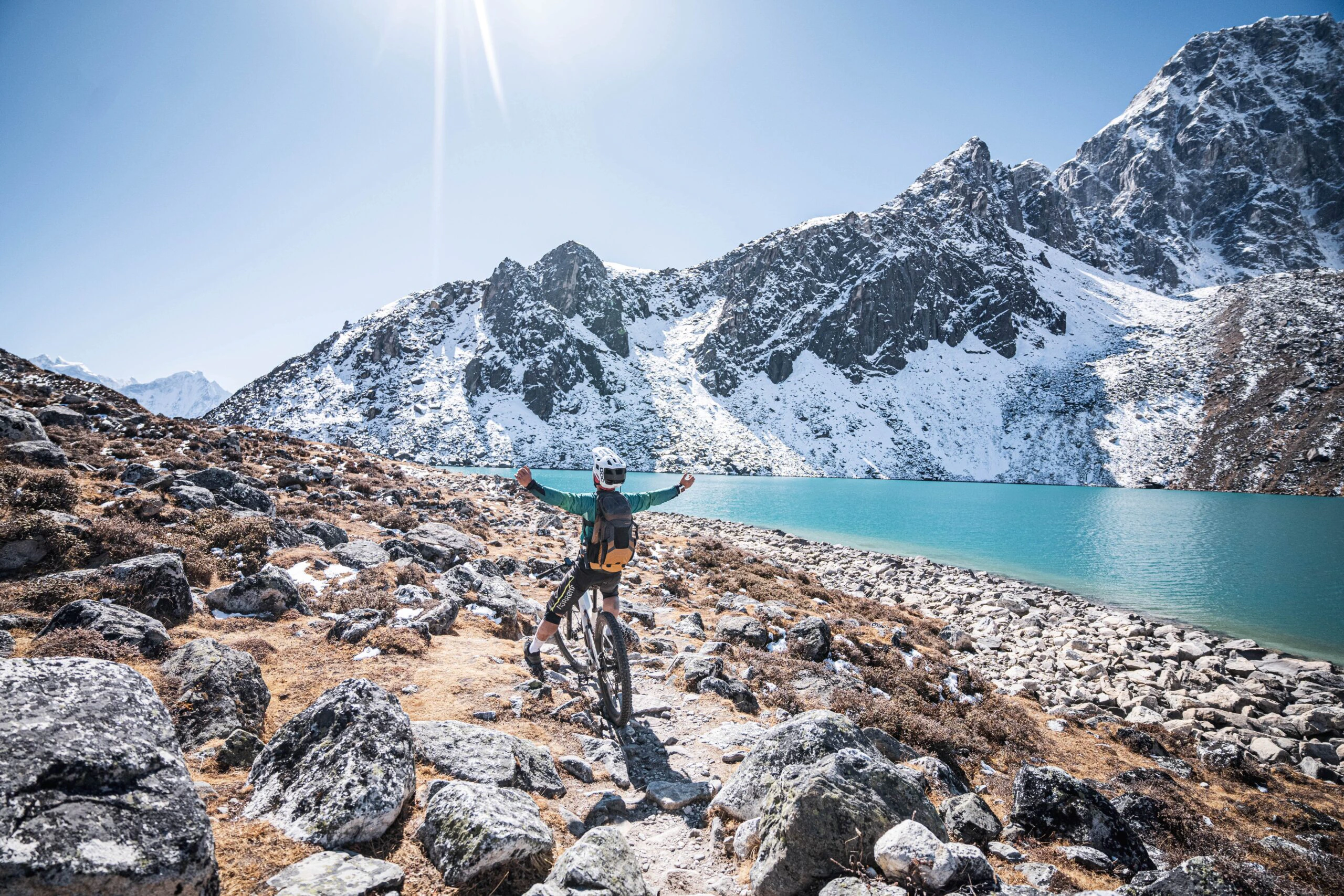 Terrengsyklist ved et fjellvann i Nepal
